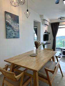 a dining room with a wooden table and chairs at Apartment in Kulai Bandar Putra in Kulai