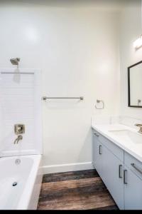 a white bathroom with a tub and a sink at The Hamptons in Mesa