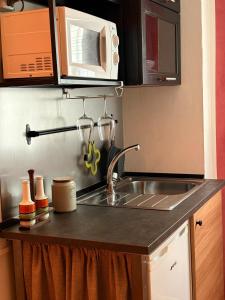 una cocina con fregadero y microondas en Mini Appartamento in Centro Storico, en Módena
