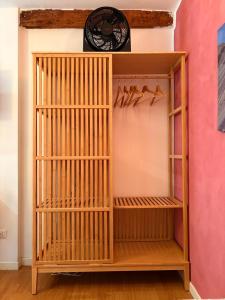 Una estantería de madera en una habitación con un reloj. en Mini Appartamento in Centro Storico, en Módena