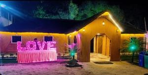 ラクナウにあるRajwada Rooms, Restaurant & Banquetのピンクの灯りが灯る家