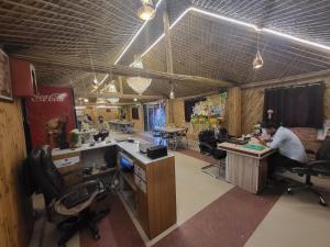 ラクナウにあるRajwada Rooms, Restaurant & Banquetの机と椅子に座っている男性のいるオフィス