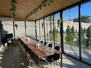 a long wooden table and chairs in a room with windows at Mughni Family House in Ashtarak +12 photos