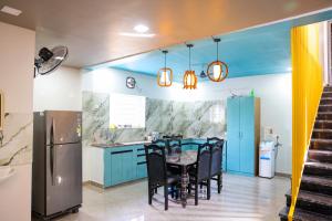 a kitchen with blue cabinets and a table and chairs at SPK farmhouse in Medchal