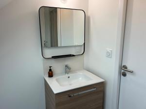 une salle de bains avec un lavabo et un miroir dans l'établissement La Perle Cancalaise - studio au cœur du Port, à Cancale 12 autres photos