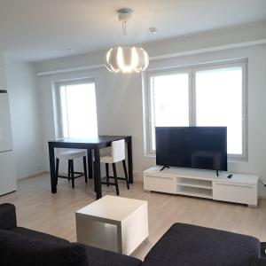 a living room with a tv and a dining room table at Northern 2-room apartment with Sauna and Garage in Rovaniemi