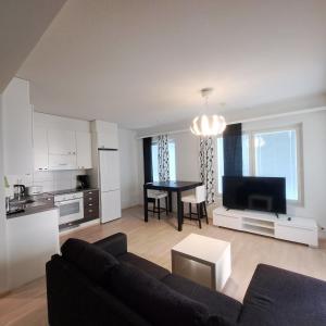 a living room with a couch and a table and a kitchen at Northern 2-room apartment with Sauna and Garage in Rovaniemi