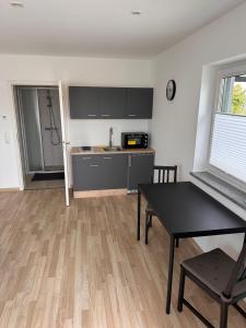 a living room with a table and a kitchen at Ferienwohnung Stefan Frank in Hengersberg