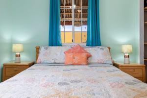 a bedroom with a bed with blue walls and two lamps at Casa de Reyes in Palm-Eagle Beach +30 photos
