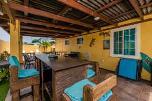 a patio with a bar with blue cushioned chairs at Casa de Reyes in Palm-Eagle Beach
