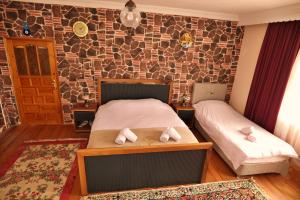 a bedroom with two beds and a brick wall at Your Cappadocia in Göreme +19 photos