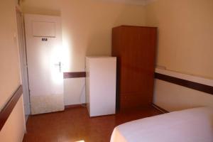 a room with a white refrigerator and a cabinet at Casa diária in Sao Paulo
