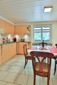 a kitchen with a wooden table and chairs and a table and a tablektop at Wohlfühlwohnung nahe Basel und der Natur des Jura in Liesberg
