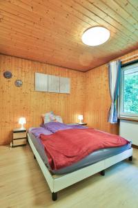 a bedroom with a large bed in a room with wooden walls at Wohlfühlwohnung nahe Basel und der Natur des Jura in Liesberg