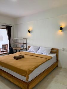 una camera da letto con un grande letto con una coperta marrone di Bale Hotel & Cowork a Kuta Lombok