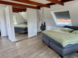a bedroom with two beds and a large mirror at Ferienhaus Neeborg in Zetel