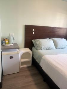 a bedroom with a bed with a wooden headboard at Darwin Budget Units in Darwin