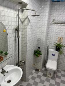 a bathroom with a white toilet and a sink at Đậu Biếc Homestay 