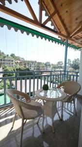 a table and chairs on a balcony with a view at Kalptaru The Kumaon Retreat in Bhowāli