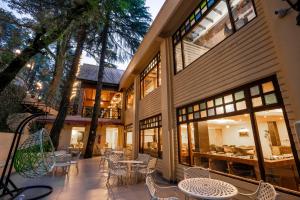 an outdoor patio with tables and chairs and windows at Snow Valley Resorts Dalhousie in Dalhousie +55 photos