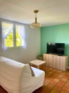 a bedroom with a bed and a flat screen tv at Duplex provençal au cœur des vignes à 5 min du centre-ville in Sablet