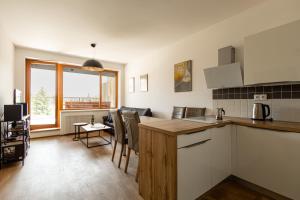 a kitchen and living room with a table and chairs at Apartmán Čihadla in Bedřichov
