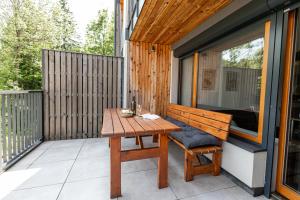a wooden table and a bench on a balcony at Apartmán Čihadla in Bedřichov