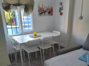 a white table and chairs in a room with a window at A beautiful Townhouse in Rute