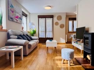 a living room with a couch and a tv at Apartamento Acogedor con Vistas Espectaculares en Liébana, Picos de Europa in Camaleño