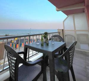 a table and chairs on a balcony with the ocean at De frente al mar in Sueca