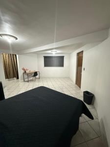 a room with a black bed and a table at Casa en segunda planta in Hidalgo del Parral