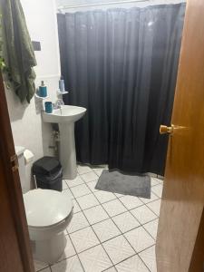 a bathroom with a black shower curtain and a toilet at Casa en segunda planta in Hidalgo del Parral
