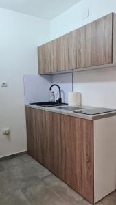 a kitchen with wooden cabinets and a sink at Apartman 47A in Valjevo