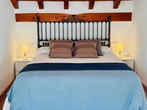 a bedroom with a large blue bed with two lamps at Apartamento Acogedor con Vistas Espectaculares en Liébana, Picos de Europa in Camaleño