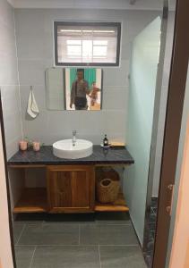 ein Badezimmer mit Waschbecken und Spiegel in der Unterkunft Tropical Rustic 4BR Villa, South Phu Quoc in Phu Quoc