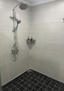 eine Dusche in einem Badezimmer mit schwarzem Fliesenboden in der Unterkunft Tropical Rustic 4BR Villa, South Phu Quoc in Phu Quoc