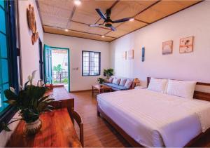 ein Schlafzimmer mit Bett und Deckenventilator in der Unterkunft Tropical Rustic 4BR Villa, South Phu Quoc in Phu Quoc
