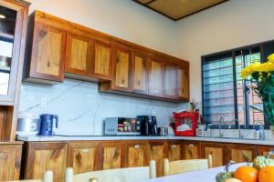 eine Küche mit Holzschränken und einer Arbeitsplatte in der Unterkunft Tropical Rustic 4BR Villa, South Phu Quoc in Phu Quoc + 18 Fotos