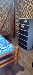 a bedroom with a dresser and a bed and a trash can at Dumaguete Divers in Dauin
