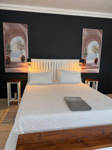 a bedroom with a large white bed with two windows at Atterbury Value Bed and Breakfast in Pretoria +13 photos