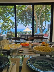 a table with food on it with a view of the ocean at Bayshore 76 Beachfront Villa Palmar de ocoa in Palmar de Ocoa