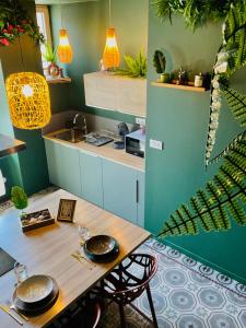 a kitchen with a wooden table with chairs and a sink at Jungle Chic Apartment, Balneo, Close to center in Belfort
