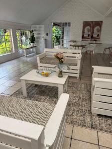 a living room with white benches and a table at Atterbury Value Bed and Breakfast in Pretoria