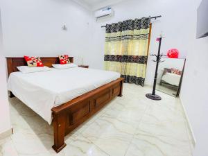 een slaapkamer met een groot bed en een spiegel bij RoseMary Villa in Hambantota