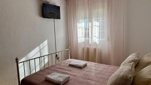 Un dormitorio con una cama con dos toallas encima. en Amanecer zen, en Argés