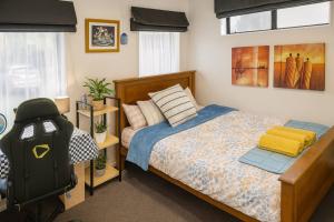 a bedroom with a bed and a chair in it at Queen Bed with Private Bath TV kitchen access and one Parking in Rolleston