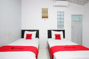 ジョグジャカルタにあるRedDoorz near Lippo Mall Yogyakarta 3の白い部屋のベッド2台 赤い枕付 +43枚の写真
