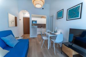 a living room with a blue couch and a table at Pico Apartments - Roma 20 in Sanremo
