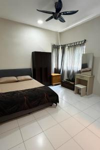 a bedroom with a bed and a ceiling fan at Ayaan Quintet Evergreen with FIFA & Private Parking in Tanah Rata