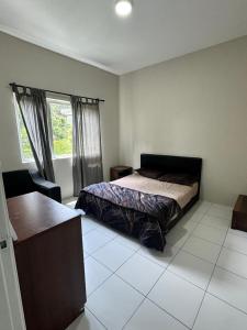 a bedroom with a bed and a window at Ayaan Quintet Evergreen with FIFA & Private Parking in Tanah Rata
